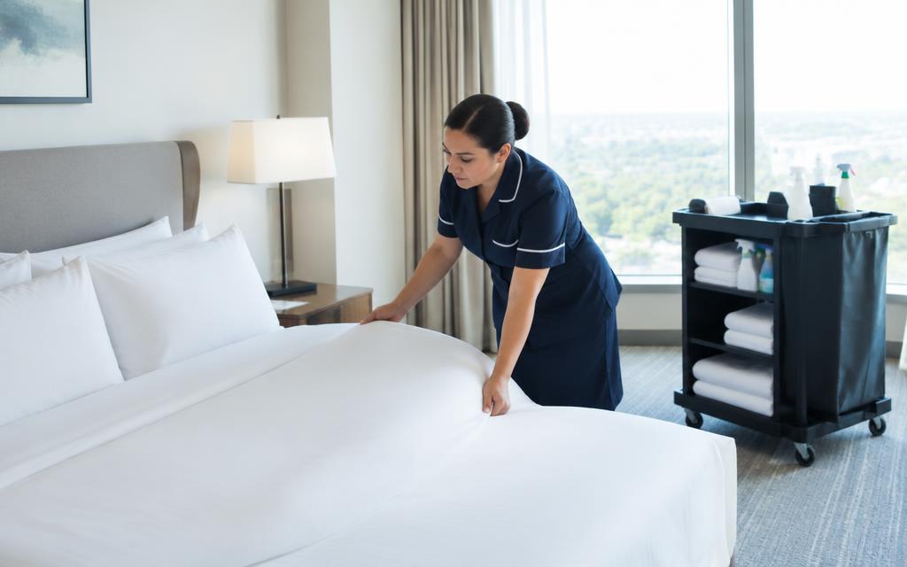 Housekeeping-Kraft richtet ein Hotelbett her